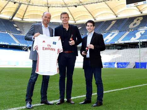 Coca-Cola verlängert beim HSV - Per Jensen (Geschäftsleiter Coca-Cola Nord, Coca-Cola Erfrischungsgetränke GmbH), Joachim Hilke (Vorstand Marketing, HSV Fußball AG) und Jonathan F. Döhling (Leiter Regionales Marketing, Coca-Cola Erfrischungsgetränke GmbH) mit HSV-Trikot und Coca-Cola-Flaschen (v.l.n.r.) – Foto: Lagardère Sports