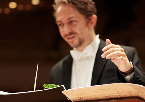 Karajan-Akademie der Berliner Philharmoniker und Scholz & Friends inszenieren Insekten-Konzert - Gregor A. Mayrhofer, Dirigierstipendiat der Karajan-Akademie, dirigiert ein Konzert gespielt von und mit Insekten (Foto: Scholz & Friends)