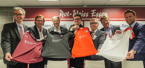 Rot-Weiss Essen freut sich über den neuen Sponsor Netzwerk Essen.Gesund.Vernetzt. - Prof. Dr. med. Heinrich Wieneke (Direktor Klinik für Kardiologie und Angiologie der Contilia), Heinz Diste (Geschäftsführer der Contilia), Prof. Dr. Jochen A. Werner (Ärztlicher Direktor des Uniklinikums Essen), Prof. Dr. Michael Welling (1. Vorsitzender von Rot-Weiss Essen), Udo Maas (Geschäftsführer ROESER Medical GmbH), Winfried Book (Geschäftsführer der Arbeitsgemeinschaft "Essen forscht und heilt") und Björn Zeien (Politik und strategische Netzwerke der Opta Data Abrechnungs GmbH) präsentieren die rot-weisse Trikotbrust (v.l.n.nr. – Foto: Rot-Weiss Essen)