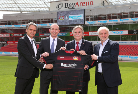 Barmenia wird Haupt- und Trikot-Sponsor bei Bayer 04 Leverkusen - Präsentieren das neue Bayer 04-Trikot bei der Bekanntgabe des neuen Hauptsponsoring-Vertrages: Frank Lamsfuß (Vorstand Barmenia), Dr. Andreas Eurich (Vorstandsvorsitzender Barmenia),Michael Schade (Geschäftsführer Bayer 04 Leverkusen Fussball GmbH) und Rudi Völler (Direktor Sport Bayer 04 Leverkusen Fussball GmbH (v.l.n.r.). Foto: obs/Barmenia Versicherungen/KADLEC KSmedianet