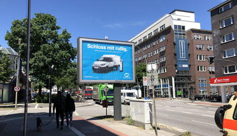 Jung von Matt/Spree gibt für die Elektrotransporter der Post Gas - Knallbunte Billboards im Dieselsperrgebiet: Streetscooter wirbt u.a. an der Hamburger Stresemannstraße (Bild: JvM/Spree)